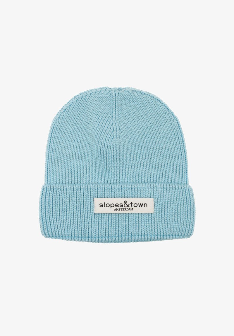 Berretto lavorato a maglia azzurro chiaro con orlo a coste. Presenta un'etichetta cucita con "slopes&town" e "AMSTERDAM" in nero. Texture morbida e design a maglia compatta.