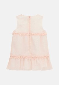Robe sans manches, rose pâle, avec un ourlet superposé et volants. Présente un motif subtil et une fermeture zippée au dos. Tissu doux et léger.