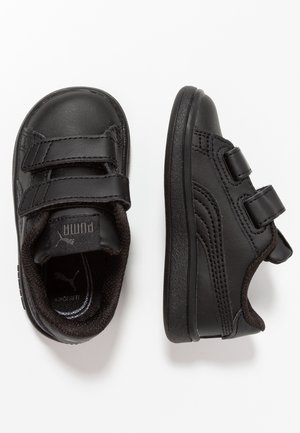 Par sorte børnesneakers med dobbelte velcrolukninger og blødt polstret inderside, vist fra top- og sideperspektiv.