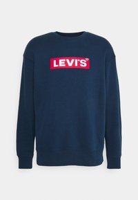 Sweat-shirt bleu marine en coton, arborant un logo « LEVI'S » blanc et rouge sur la poitrine. Poignets et col côtelés. Sans motifs.