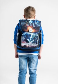 Zaino con un design blu e nero caratterizzato da illustrazioni grafiche di figure corazzate. Include una tasca frontale con cerniera e dettagli del logo.