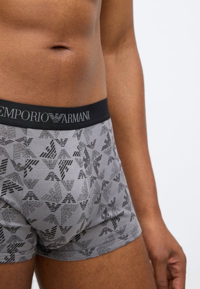 Γκρι βαμβακερά μποξεράκια με μαύρη ζώνη Emporio Armani, που διαθέτουν επαναλαμβαν�όμενο σχέδιο μαύρου λογότυπου και σχεδίαση άνετης εφαρμογής.