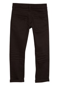 Černé džíny slim fit s hladkou texturou, dvěma zadními kapsami a ohrnutými manžetami na kotnících, minimalistický design.