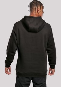 Schwarzer Kapuzenpullover aus strukturiertem Stoff, mit gerippten Bündchen und Saum. Das Design ist einfach mit einer taillierten Silhouette und einem lässigen Aussehen.