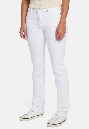 Witte denim jeans met een slim fit, hoge taille en subtiele stiksels. Gecombineerd met witte sneakers met zwarte accenten.