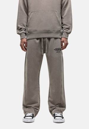 Grauer Sweatshirt und passende Hose aus weichem Material, mit einer Vordertasche und gesticktem Logodetail auf der Hose.