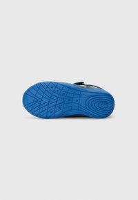 Blauer Gummi-Außensohle mit strukturiertem Grip-Muster, das kreisförmige Details und Rillen für Traktion aufweist, entworfen für Sportschuhe.