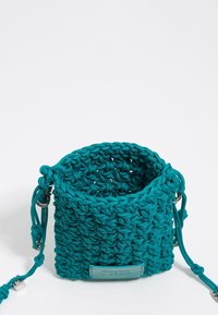 Borsa intrecciata color teal con un design testurizzato all'uncinetto. Presenta cordini regolabili e un piccolo etichetta in pelle sulla parte anteriore.