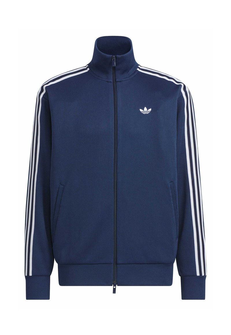 Giacca sportiva con cerniera blu navy con tre strisce bianche sulle maniche e logo Adidas bianco sul petto, polsini e orlo a coste.