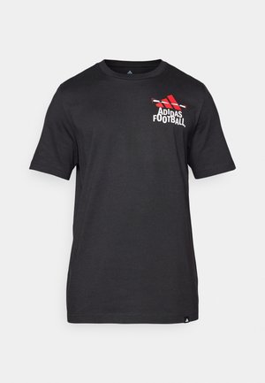 Svart kortermet T-skjorte laget av bomull, med en rød Adidas-logo og teksten "Football" på venstre brystområde. Glatt tekstur.
