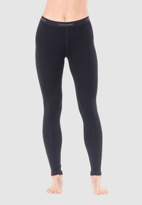 Black leggings made of stretchy material with a wide elastic waistband featuring the "icebreaker" logo. Smooth texture, fitted design.