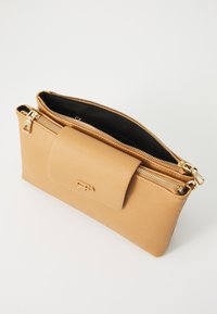 Clutch de cuero marrón claro con acabado texturizado, que cuenta con un cierre superior con cremallera y una solapa con un broche magnético. Incluye acentos de hardware en dorado.