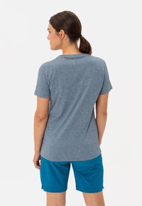 Svetle modrošedé tričko s krátkým rukávem a kulatým výstřihem, s jemně texturovaným povrchem, doplněné tyrkysovými šortkami s kapsami.