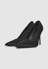 Tacchi alti neri a punta con una finitura texture, dotati di un sottile tacco a stiletto e un design elegante e slanciato.