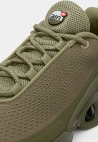 Oliwkowe sneakersy Nike Air Max z teksturowaną cholewką, siateczkowym językiem, okrągłymi sznurowadłami i logo Air Max na wyściełanym języku.