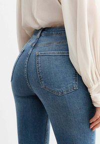 Hoge taille blauwe denim jeans met een vijf-pocket ontwerp, zichtbare stiksels en een lichte stretch. Soepele textuur en slim fit silhouet.