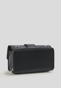 Borsa in pelle nera con forma rettangolare, texture liscia, chiusura con zip e dettagli metallici. Presenta una maniglia robusta nella parte superiore.