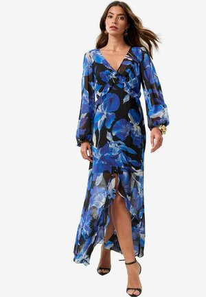 Rochie maxi din material ușor, transparent, cu un fundal negru și un model floral albastru. Are mâneci lungi și o fanta frontală.