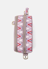 Kompaktní obdélníková taška se dvěma zlatými zipy, růžovým a červeným geometrickým vzorem a zlatou přezkou na bílém pozadí.