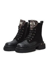 Schwarze Stiefel mit einer strukturierten Kunstlederzehe, Obermaterial aus Wildleder, Innenfutter mit Leopardenmuster, silbernen Akzentbeschlägen und einer massiven Gummisohle.