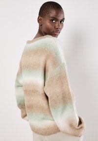 Übergroßer Strickpullover mit einem Farbverlauf aus beige, mintgrünen und weißen Streifen. Weiche Textur, weite Ärmel und lässige Passform.