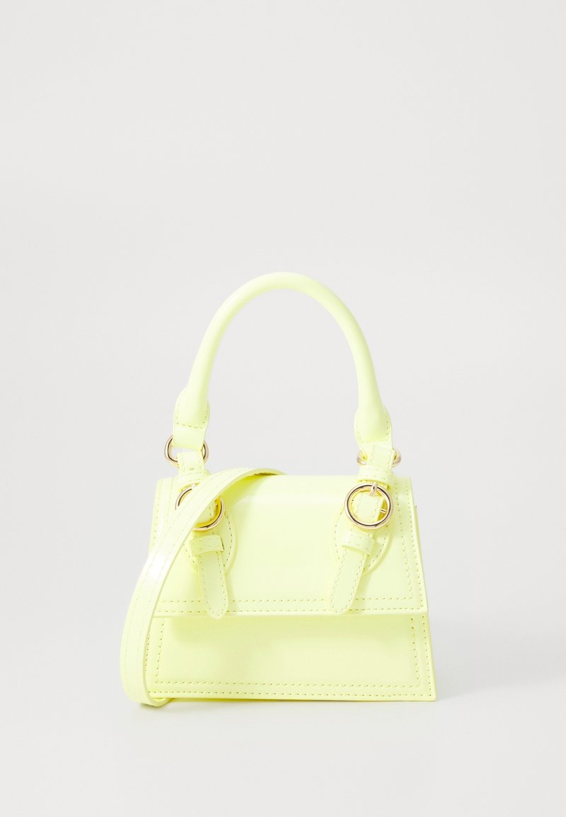Sac à main jaune néon en matériau brillant. Présente une forme structurée, deux poignées courtes et une bandoulière amovible avec des ferrures dorées.