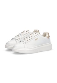 Zapatillas blancas de corte bajo con detalles dorados en el talón y los ojales, cordones blancos y suelas gruesas con tacos, posicionadas una al lado de la otra sobre un fondo blanco.