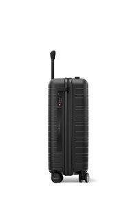 Black hard-shell suitcase with vertical ridges, a retractable handle, a combination lock, and two spinner wheels for mobility.