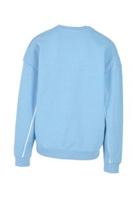Felpa azzurra chiara con scollatura rotonda, spalle scese e dettagli bianchi sui lati. Realizzata in morbido misto cotone, vestibilità rilassata e polsini a costine.