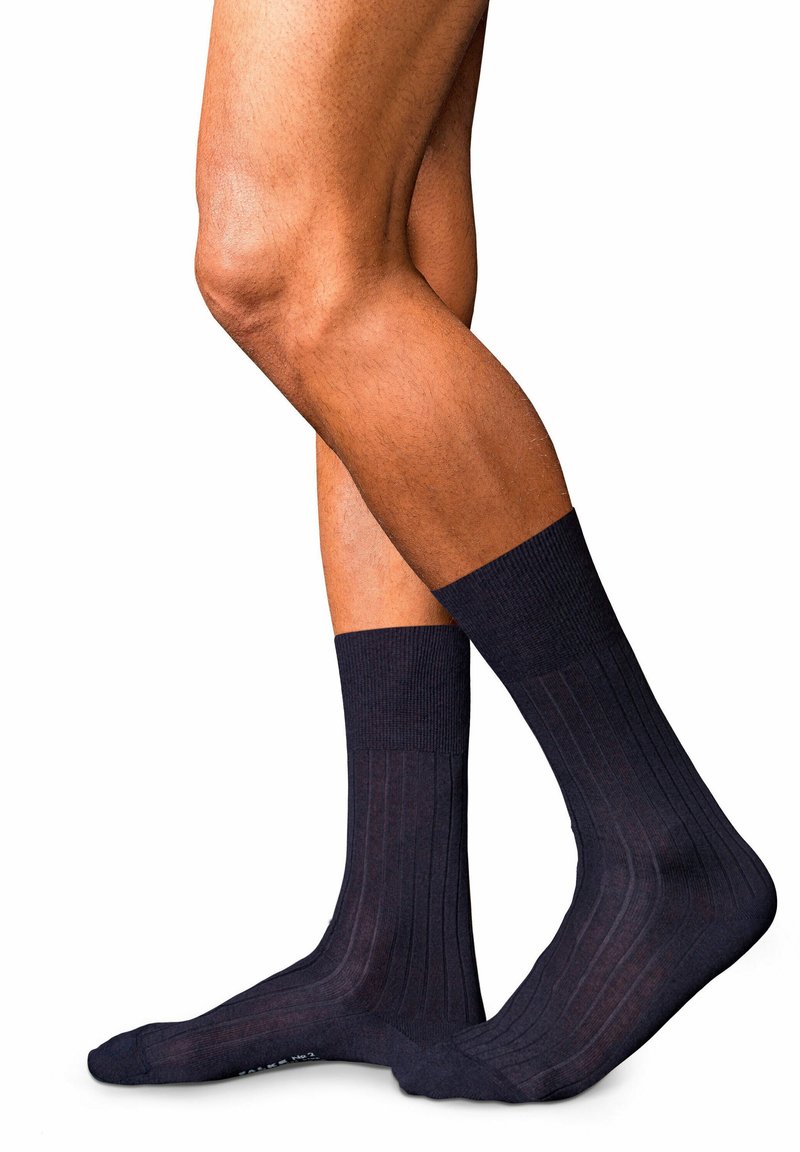 Calze in cotone a costine di un blu scuro, con punta e bordo rinforzati. La texture appare liscia e morbida. Gli accenti includono sottili motivi a costine.