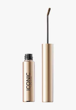 Tube de mascara doré avec une marque noire. La brosse a une forme incurvée et des poils courts, conçue pour une application précise.