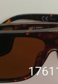 Hnědé želvovinové sluneční brýle s tmavými skly, na vnitřní straně obrouček s bílými textovými štítky "CE" a "CAT.3 CHINA".