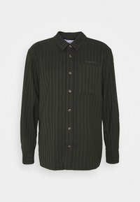 Mörkgrön randig skjorta med krage som knäpps, långa ärmar och bröstficka; har bruna knappar och strukturerad tyg.