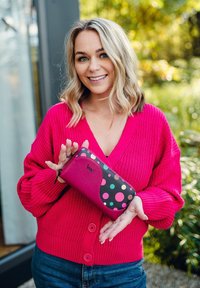 Wallet with pink and black color scheme, featuring colorful polka dots and a zipper. Made of synthetic material with a smooth texture.