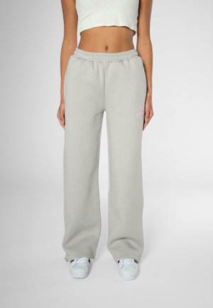 Light gray sweatpants with a loose fit, elastic waistband, and subtle pink logo detailing on the left thigh. Pairing with white sneakers.