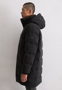 Schwarze Daunenjacke mit Kapuze, featuring eine glatte Textur, horizontales Steppdesign und einem Markenlogo auf dem linken Ärmel.