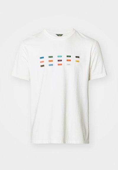 Camiseta blanca de algodón que presenta varias etiquetas de tela coloridas con la palabra "Lee" y otro texto. Diseño clásico de cuello redondo, mangas cortas.