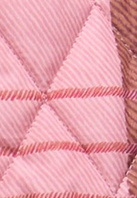 Ραμμένο ύφασμα σε ροζ με ανυψωμένο, διαγώνιο διαμαντένιο σχέδιο και διακριτική ριμπ υφή; διαθέτει αντίθετα καφέ ραφές ως αξεσουάρ.