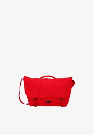 Rote Timbuk2 Messenger-Tasche mit Klappenverschluss, verstellbarem Schultergurt und obenliegendem Tragegriff vor weißem Hintergrund.