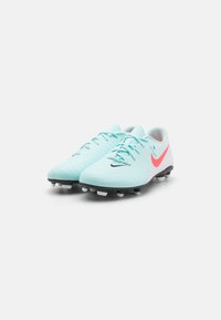 Világoskék focicipők, texturált felülettel, fekete talppal, fehér stoplikkal és piros Nike pipa kiegészítéssel. Fecskendőzéssel és kerek orrú dizájnnal rendelkezik.