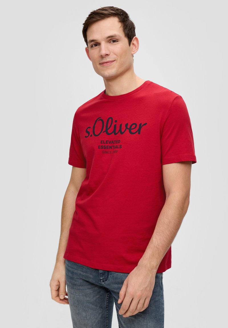 Rode katoenen t-shirt met korte mouwen en een ronde hals, voorzien van een marineblauwe gedrukte merknaam en tekst op de voorkant. Effen textuur.