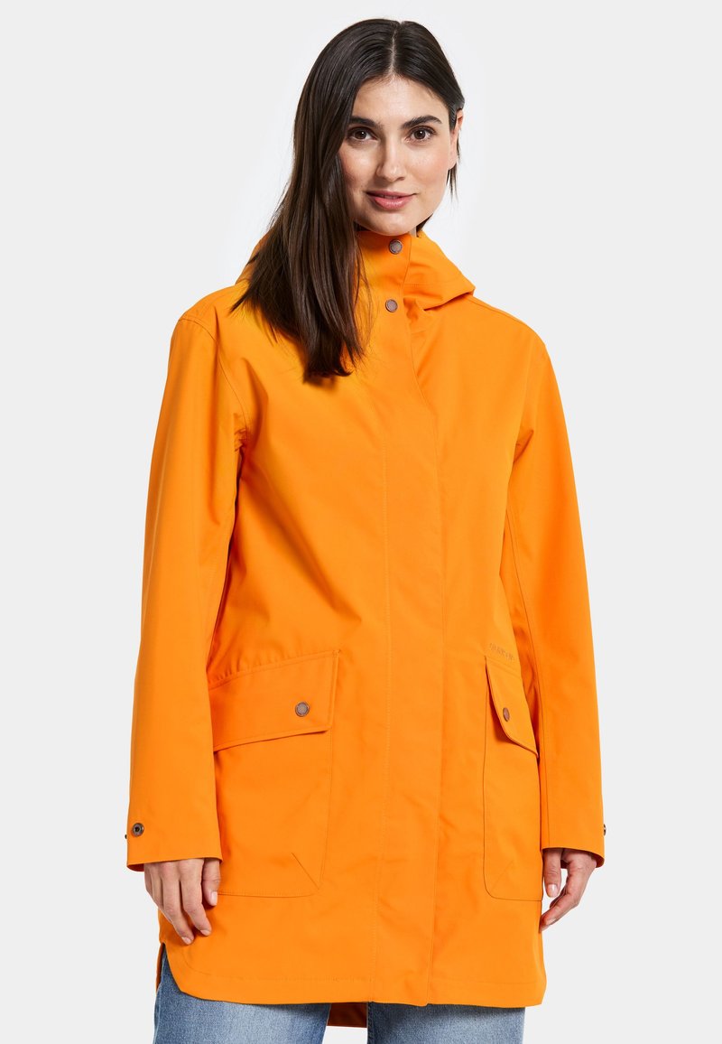 Orange vattentät jacka med huva, med rak skärning, tryckknappstängning fram och två sidofickor. Slät textur, avslappnad design.