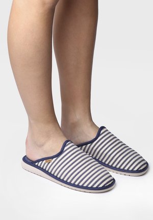 Striped indoor slippers with a navy and cream color scheme, fabric upper, open back design, and soft sole. Features minimal branding detail.