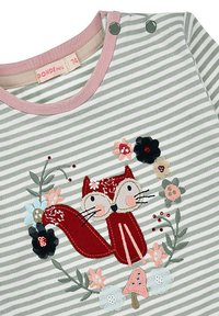 Gestreiftes Hemd aus grünem und weißem Stoff mit einer roten Fuchs-Stickerei, umgeben von Blumen und Blättern, mit rosa Akzenten am Halsausschnitt.