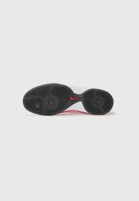 Semelle de chaussure de sport blanche avec un motif de semelle en caoutchouc noir, arborant un logo Nike rouge et deux accents circulaires noirs pour une meilleure adhérence.