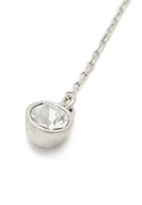 Silverkedjehalsband med en oval genomskinlig ädelsten inlagd i en rund bezel. Slät metalltextur med en polerad yta.