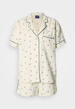 Kortærmet pyjamasæt i cremefarve med lille blomstertryk. Har grøn kantning, en brystlomme og matchende shorts. Designet for komfort.