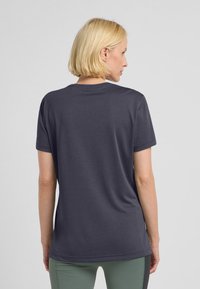 Grijze T-shirt met korte mouwen en ronde hals, soepele textuur en een iets losse pasvorm, zichtbare stiksels langs de zoom.