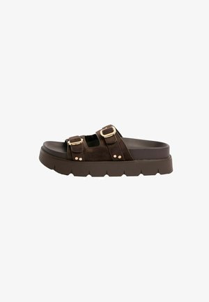 Brown slide sandal with two adjustable buckle straps and thick textured sole, displayed side view on white background.