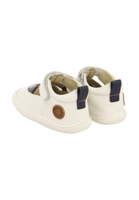 Zapatos infantiles de cuero blanco con detalles en azul marino, cierre de velcro, punta redonda y suela de goma texturizada; cuentan con un detalle de logo en el talón.